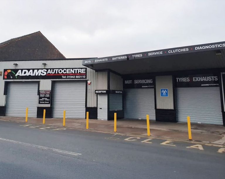 Adams Autocentre frontage with 4 large, grey doors for the vehicles to enter through.
